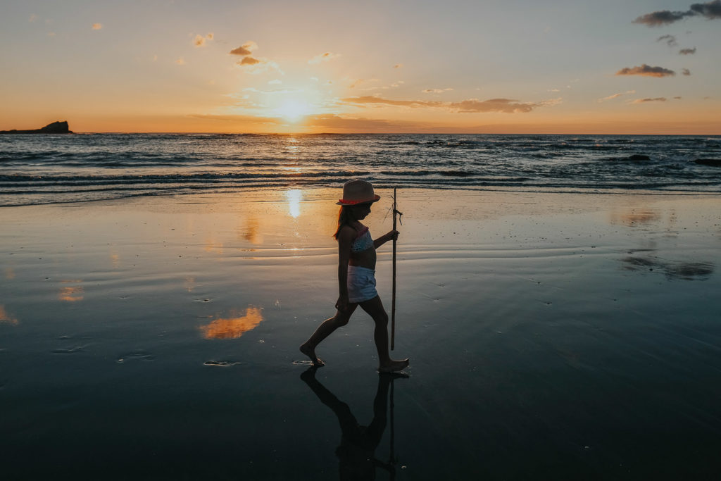 girl on beach at playa pelada silohuette at sunset nosara costa rica wedding photographer