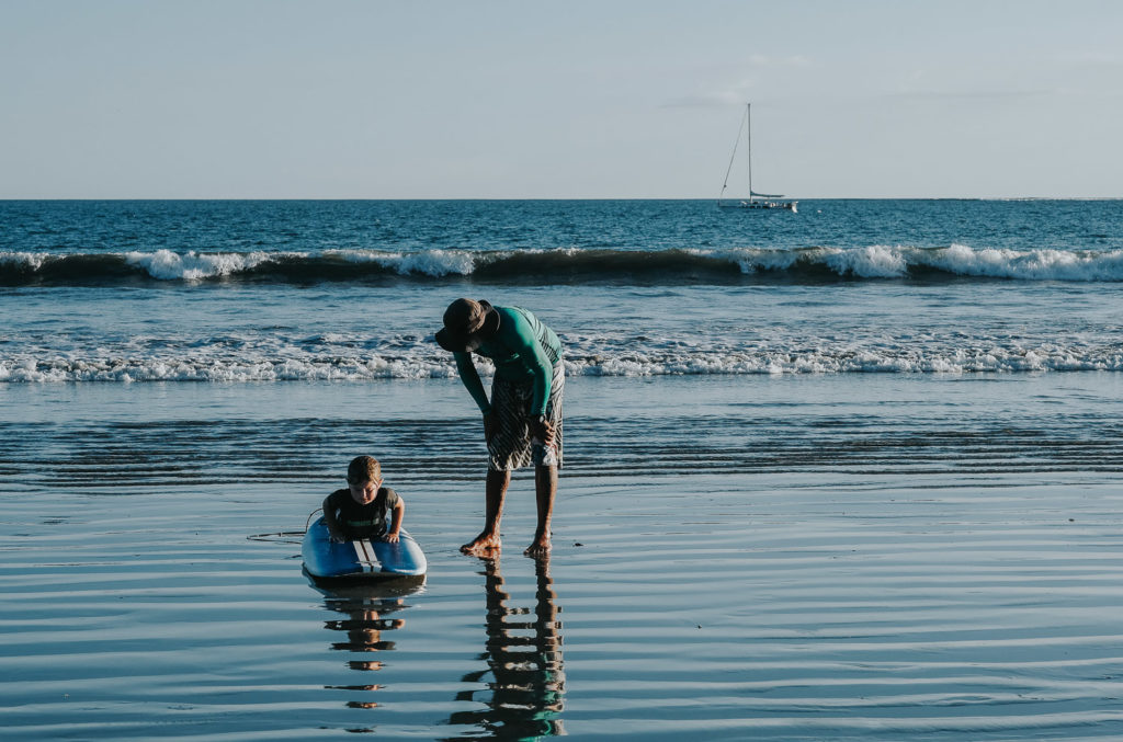 small child learning to surf in costa rica