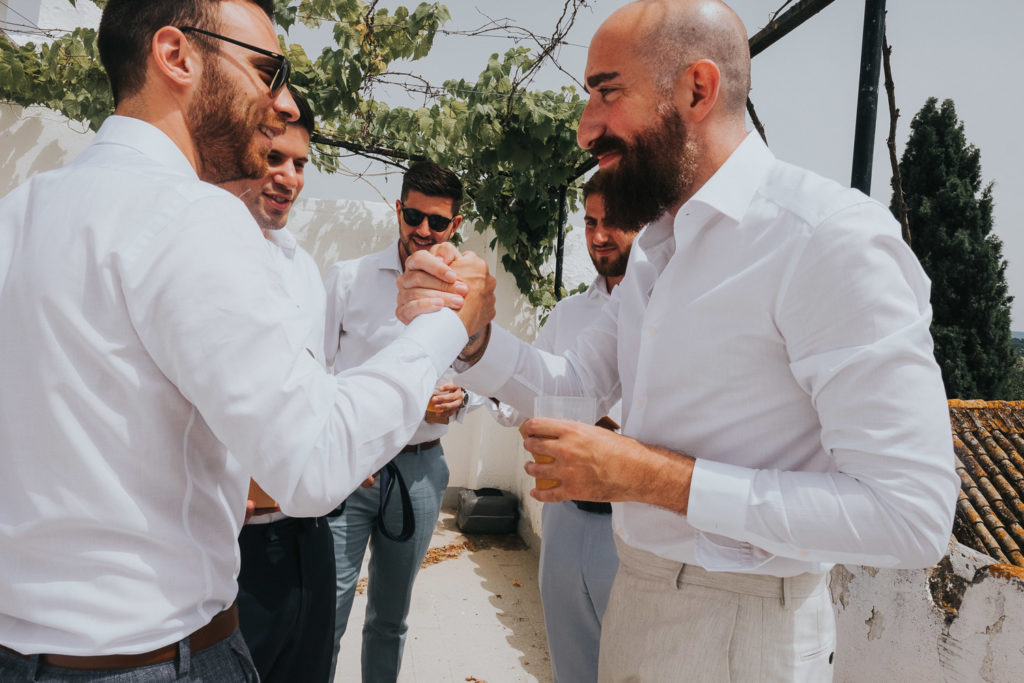 groomsmen drinking whisky shots on sunny terrace jerez wedding photographer