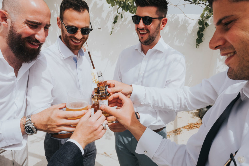 groomsmen drinking whisky shots on sunny terrace jerez wedding photographer