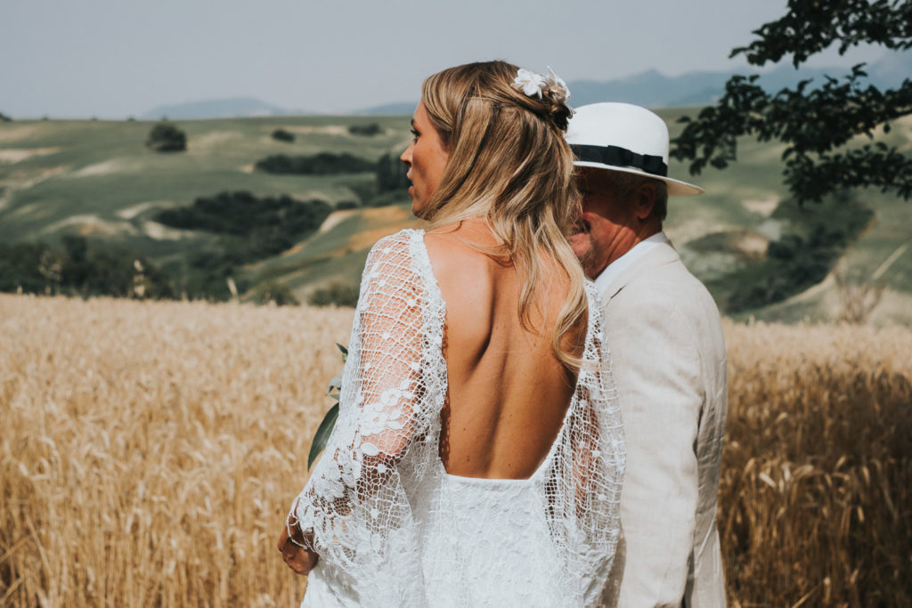 bride and her father from the back standing in wheat field jerez wedding photographer cortijo barranco