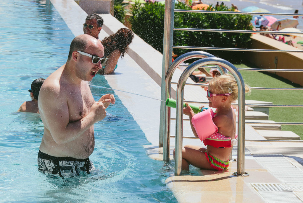 SOL Y MAR CALPE COSTA BLANCA WEDDING PHOTOGRAPHER CHILD WITH WATER PISTOL IN SWIMMING POOL