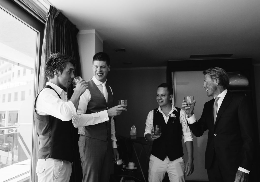 SOL Y MAR CALPE COSTA BLANCA WEDDING PHOTOGRAPHER BLACK AND WHITE GROOMSMEN DRINKING WHISKY TOGETHER