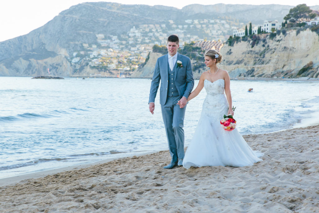 SOL Y MAR CALPE COSTA BLANCA WEDDING PHOTOGRAPHER BRIDE AND GROOM WALKING ON BEACH