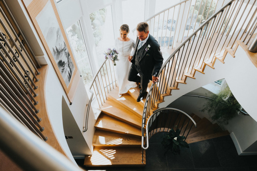 bride and father walking down stairs on wedding morning kent wedding photographer