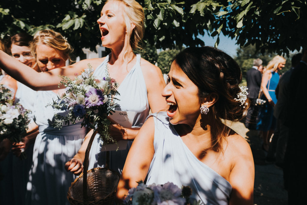 bridesmaids throwing confetti and shouting kent wedding photographer