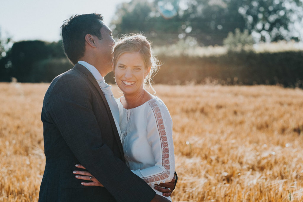 kent wedding photographer bride and groom in wheat field sun flare posing wedding photos